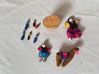 Group of dolls, knitted llama, wood drum laid out