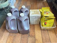 Four Stripex-L jugs, boxed packets and yellow stain-prep packets grouped on floor