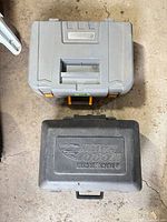 Two closed molded plastic tool cases, gray Maximum and black Black & Decker