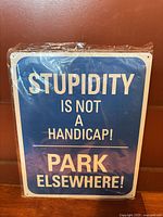 Front of blue tin sign showing text and plastic wrap