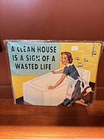 Front of tin sign showing graphic and slogan