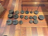 All seventeen cast-iron weights arranged on wood floor