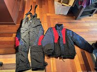 Full view of New Face ski jacket and bib pants laid out on floor