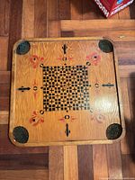 full view of checkerboard side of wooden game board with corner baskets