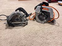 Two corded circular saws side by side on carpet