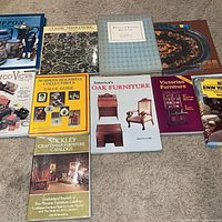 Overall view of ten antique reference books laid out on carpet