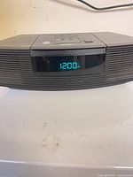 Front view showing Bose Wave Radio/CD powered on with 12:00 PM display