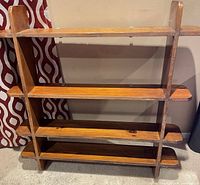 Front view of wooden wall shelf showing four shelves and side supports