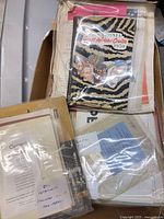 Box containing multiple plastic envelopes with brochures and pamphlets visible