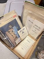 Box containing multiple envelopes and visible pamphlets such as Fontainebleau brochure