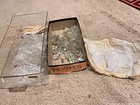 overall lot showing plastic container, cardboard box of prisms and wrapped drip pans