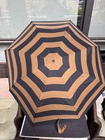 Umbrella opened showing tan and black concentric stripe pattern