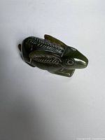 Top angled view of dark green carved jade rabbit
