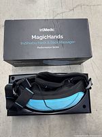 Massager in tray with original box lid showing full product name