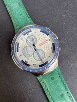 Front angled view of Benetton chronograph watch with green leather strap