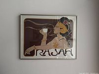 Framed Rajah coffee lithograph on wall