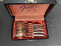 open case showing six teaspoons inside red satin interior, Jubiler P.P. marking visible