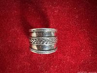 Overhead view of wide sterling band showing braided motif and hallmarks