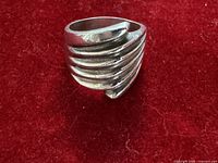 Front view of ridged sterling silver ring on red background