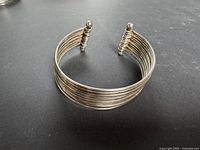 Oblique view of cuff showing parallel wire construction and finial detail