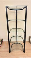 Front view of etagere showing six glass shelves and black frame