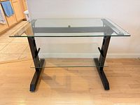 Front angled view showing two glass shelves and black metal legs