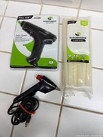 Packaged Surebonder glue gun, pack of glue sticks, compact glue gun