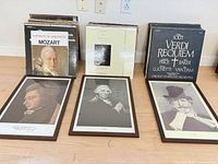 Stacks of vinyl records and three framed portraits