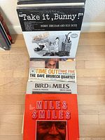 Front view of stacked records showing six titles including "Take It, Bunny", "Time Out", "Bird & Miles", "Miles Smiles"