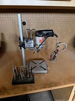 Full view of drill press stand with mounted drill and bit set