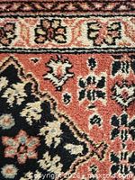 Close-up of carpet pattern, showing colors and wool texture