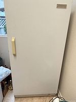 Front view of white Kenmore upright freezer with handle and nameplate visible