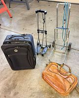 Group shot of suitcase, satchel and two luggage carts
