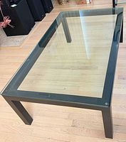 Three-quarter view showing glass top and steel frame