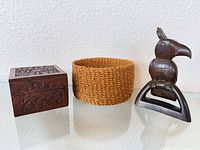 Group shot of carved wood box, woven basket, and bird sculpture