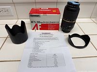 Overall lot: lens with filter attached, two hoods, box, spec sheet