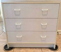 Front view showing three drawers and six handles