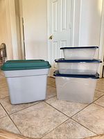 Group shot: one grey tote with green lid, three clear totes with blue lids