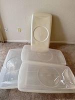 Stack of four clear YAFFA under-bed storage boxes showing lids and latching edges