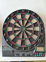 Black electronic dartboard with LCD panel and molded base