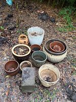 Group of assorted outdoor planters and cinder block on ground