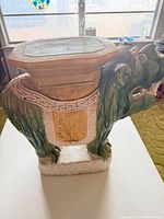 Side view of green and yellow glazed ceramic temple lion seat showing overall form and base