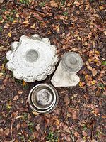 Overview of concrete garden pieces and nested stainless bowls on ground