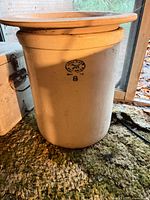 Front view of cream glazed crock with lid, blue oval stamp and 8 marking visible