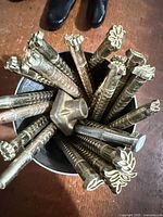 Cluster of long-shank stamps in container showing floral and geometric heads