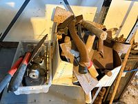 Overview of cardboard box and plastic tote with assorted rusty tools