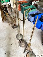 Row of four brass and bronze floor lamps with adjustable arms
