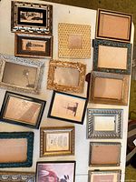 Table view of multiple rectangular picture frames in assorted finishes and sizes