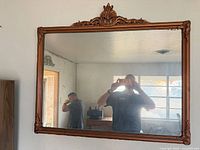 Front view of gilt framed mirror with crest