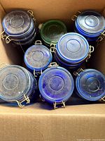 Top view of eight colored glass jars inside cardboard box